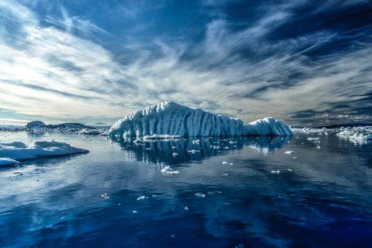 photo of iceberg, sea, and sky